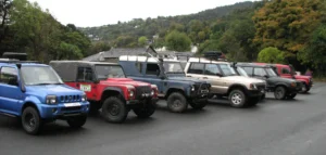 Six different makes of 4 by 4 vehicles lined up in a Laxey car park.
